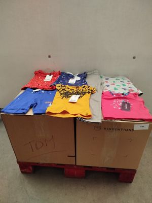 many shirts on a pallet in a room
