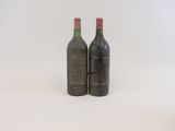 deux bouteilles de vin posées l'une à côté de l'autre sur une surface blanche