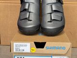 deux paires de chaussures Shimano dans une boîte posée sur une table