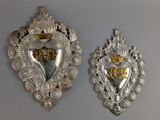 deux plaques en forme de cœur, en argent et en or, accrochées au mur