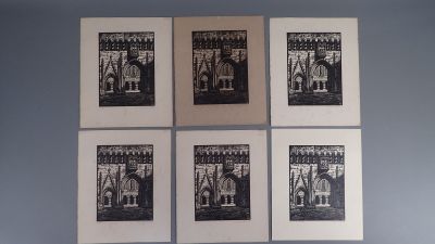quatre tirages en noir et blanc accrochés sur un mur bleu au-dessus d'un lit