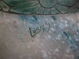 a green vase with writing on it sitting on a table