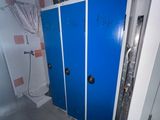 two blue lockers in a bathroom with a tv on the wall