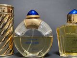 two bottles of perfume sitting next to each other on top of a table