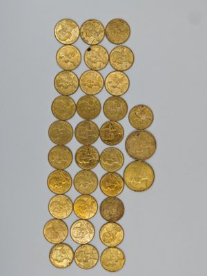 a close up of a pile of gold coins on a white surface