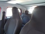 two seats in the back of a car with a sun shining through the window