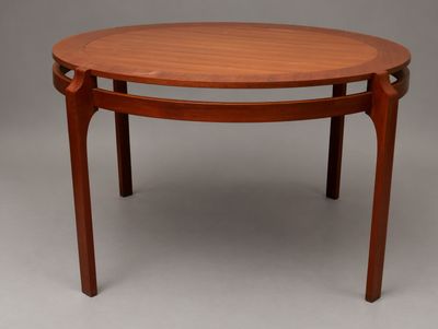 une table ronde avec un plateau et des pieds en bois