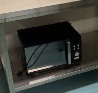 un micro-ondes posé sur une étagère dans la cuisine