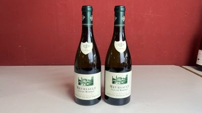 Deux bouteilles de vin sont posées sur un comptoir devant un mur rouge.