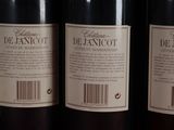 three bottles of red wine are lined up on a shelf