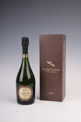 une bouteille de vin posée à côté d'une boîte sur une surface blanche