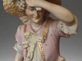 a figurine of a woman with a hat on her head
