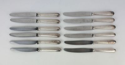 six couteaux sont alignés sur une surface blanche