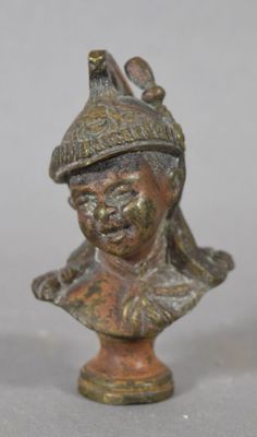 bronze bust of a man with a hat and a bird on his head
