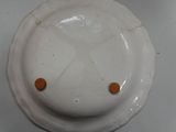 a white plate with orange buttons on it on a table