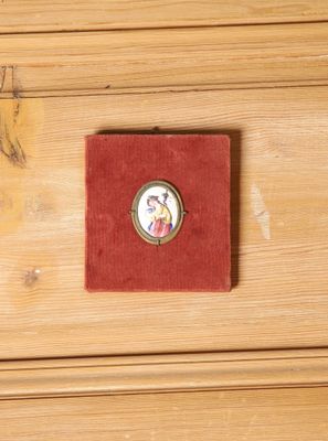 une petite boîte rouge sur laquelle est représentée une femme