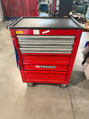 une boîte à outils rouge posée sur une table dans un garage