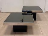 pair of chrome and glass coffee tables on a tiled floor