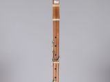 a close up of a wooden flute on a clear stand