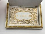 a silver box with a gold and white design on it