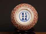 a blue and white vase on a wooden stand on a table