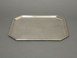 a silver tray on a table with a handle