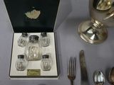 a box with silverware on a table next to a silver cup
