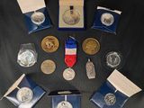 un ensemble de pièces d'argent et d'or ainsi qu'une médaille posés sur une table