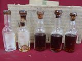 cinq petites bouteilles de liquide posées sur une table