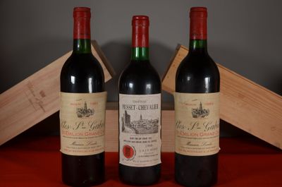 three bottles of red wine sitting next to a wooden box