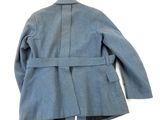 the back of a blue jacket with a belt on a white background