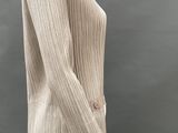 an image of a mannequin wearing a beige sweater and black pants