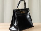 a black leather handbag sitting on top of a wooden table