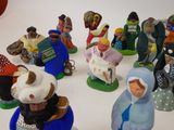 many figurines of different people on a white surface