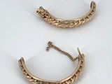 a pair of gold earrings on a white surface