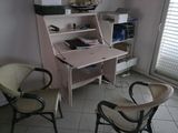 two chairs and a desk in the corner of a room