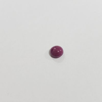 une seule pierre rouge sur une surface blanche
