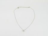 un collier blanc orné d'un petit diamant monté sur une chaîne