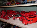 de nombreux camions de pompiers miniatures posés sur une étagère dans une pièce