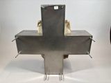 a metal cross on a stand with a bag on top of it