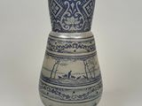 un vase bleu et blanc posé sur une surface blanche