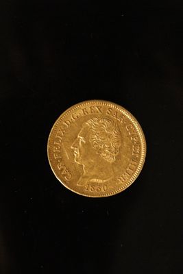 a close up of a gold coin on a black surface