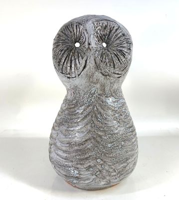 a gray vase with an owl face on it