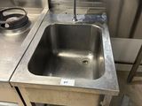 a sink in the middle of a stainless steel counter