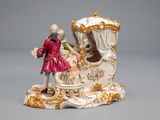 a figurine of a man and a woman in a carriage