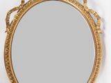 une image d'un miroir encadré d'or sur un mur blanc