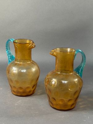 two glass vases sitting next to each other on a table