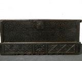 un vieux coffre en bois posé sur une table grise
