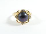un gros plan d'une bague ornée d'une perle noire et de diamants