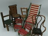 five miniature chairs and a chair that are sitting on a white surface